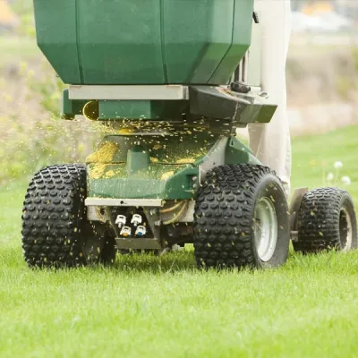 technician fertilizing a lawn