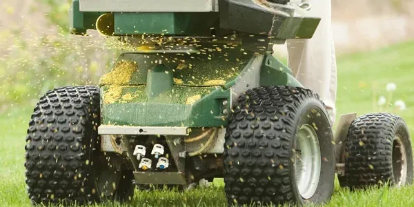 technician fertilizing a lawn